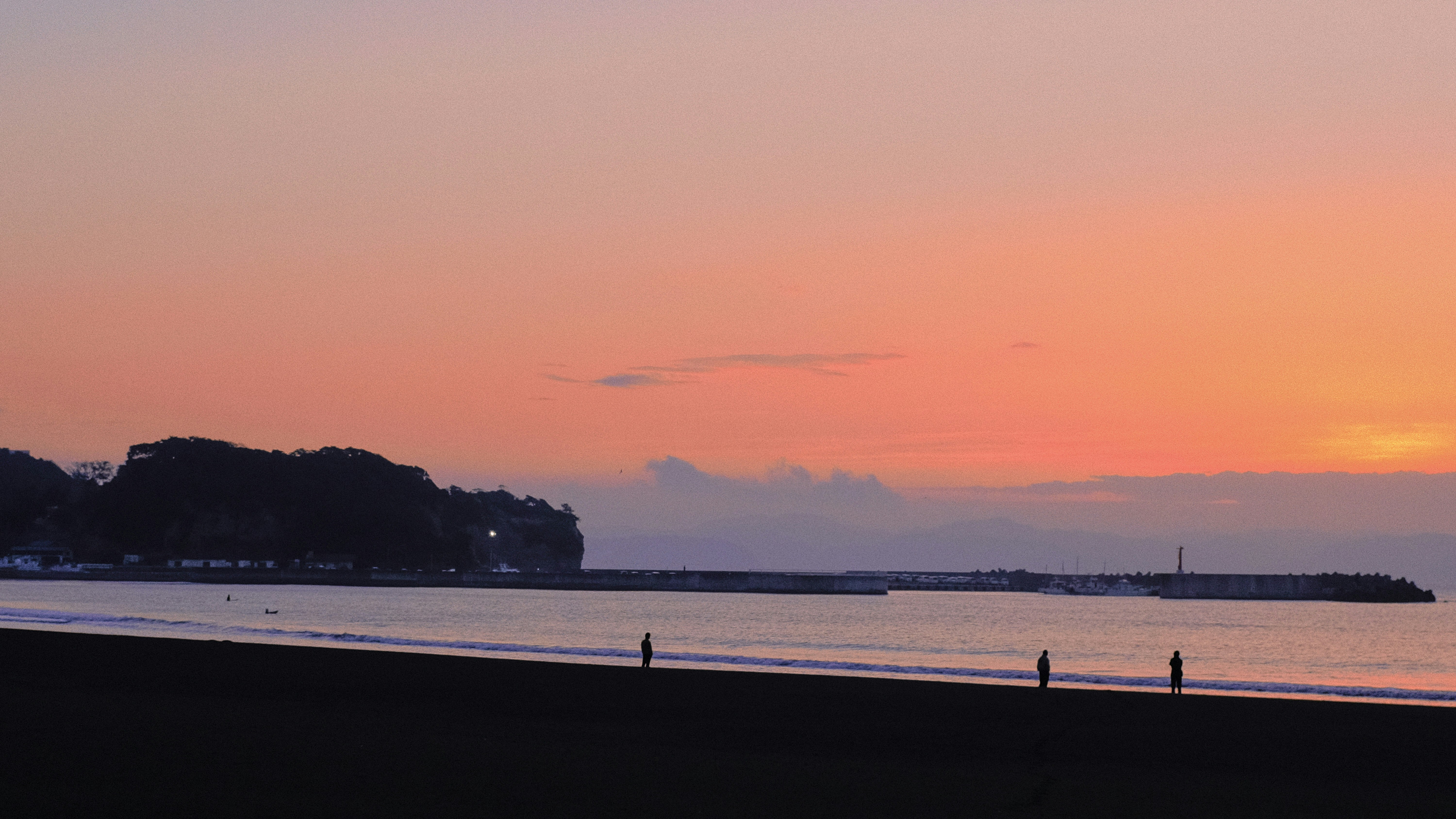 First sunrise over a tranquil Japanese coastline with torii gate