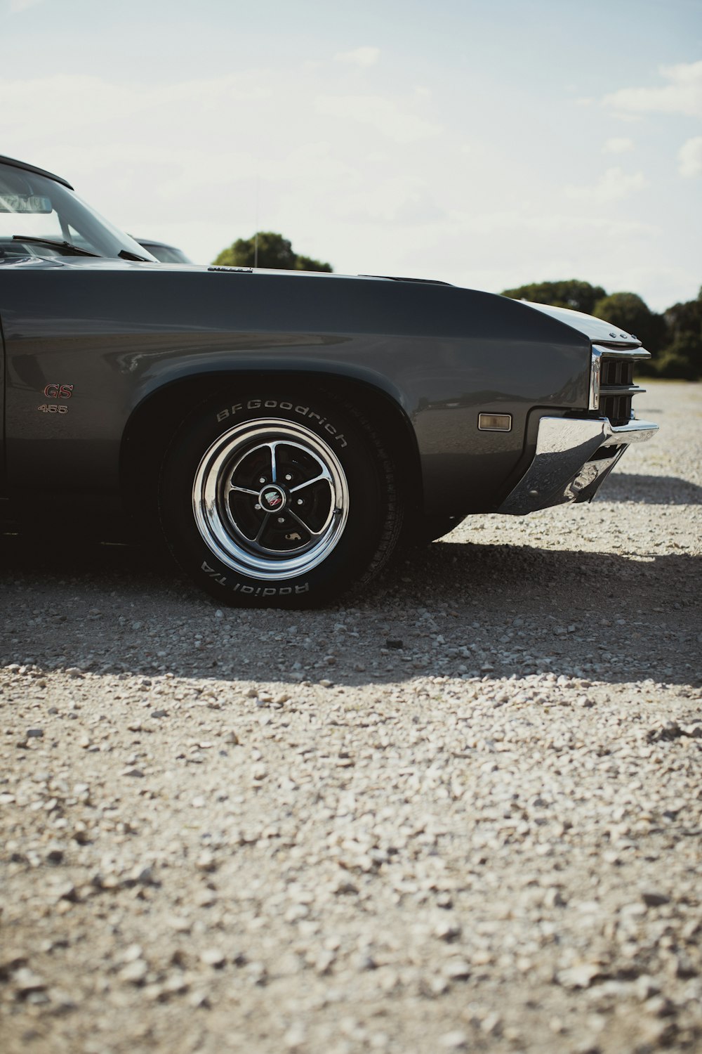 a black car parked on a dirt road