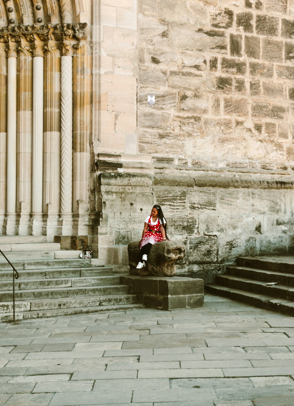 a person sitting on a stone ledge
