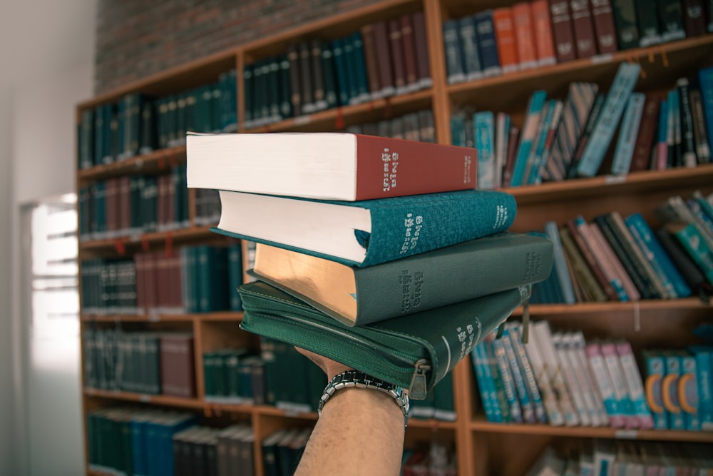 a person holding a stack of books