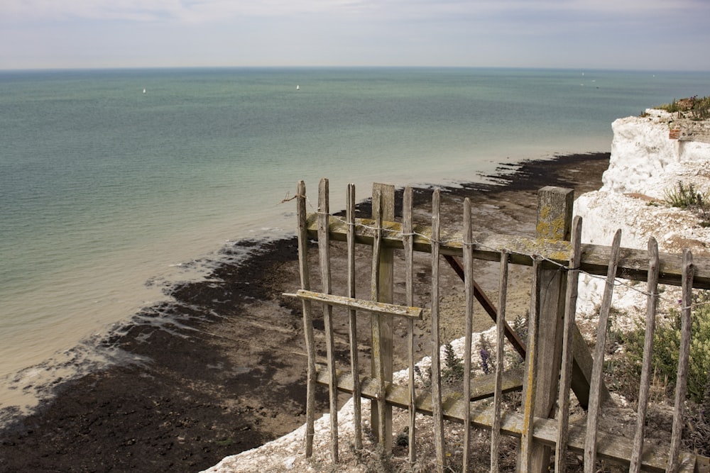 a wooden fence on a beach