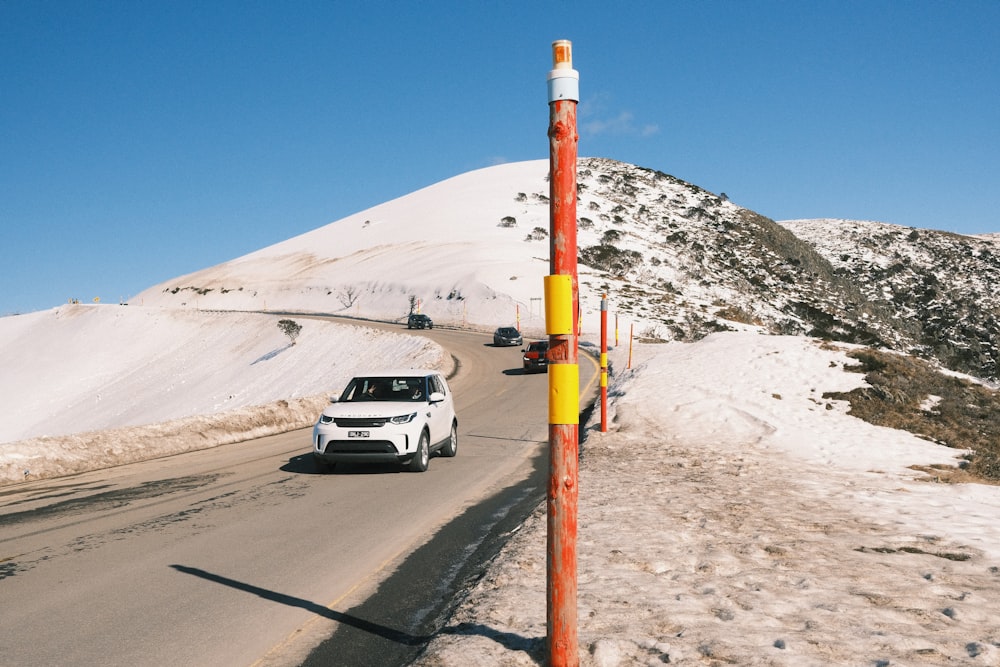 a car on a road with snow on the side