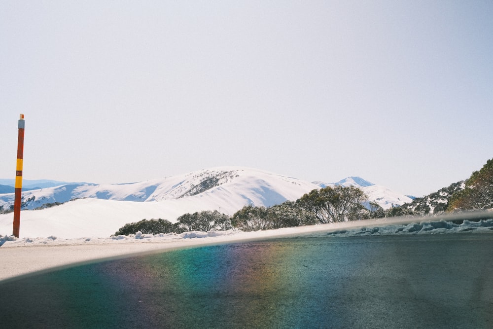 a body of water with snow covered mountains in the background