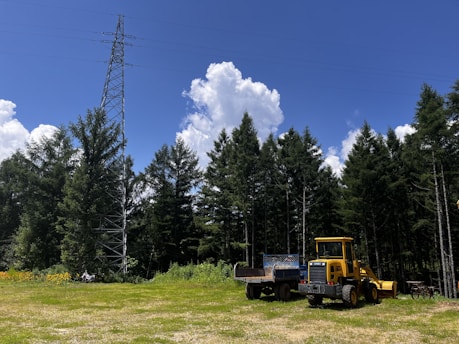 Heavy-duty pile driving machine operating on a solar farm under clear blue skies.
