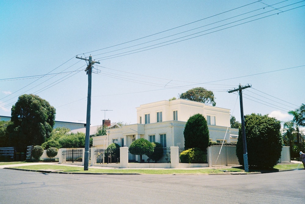 a white house with trees and power lines