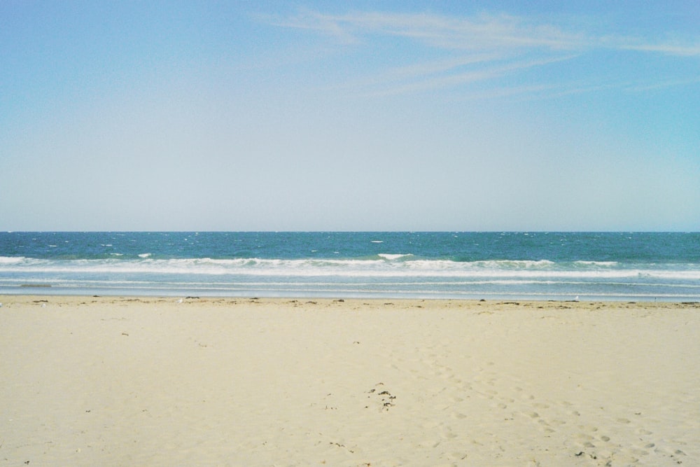 a sandy beach with waves crashing