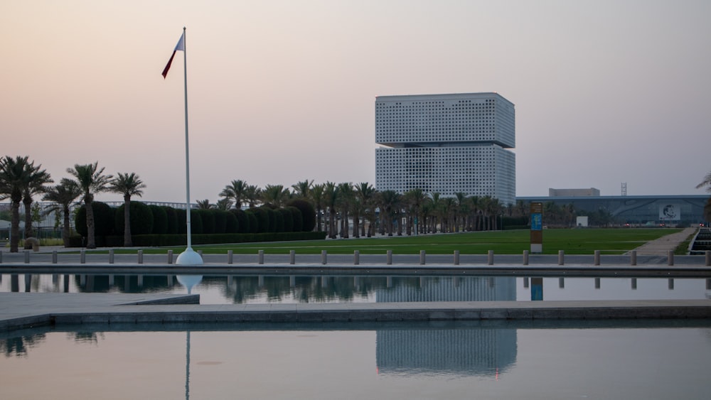 un cuerpo de agua con una bandera y un edificio al fondo