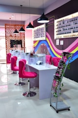 a pink chair in a room with a table and chairs