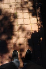 Happy customer wearing grooubra shoes walking in a sunny street.