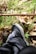 A close-up of sneakers on a park path, surrounded by greenery and sunlight.