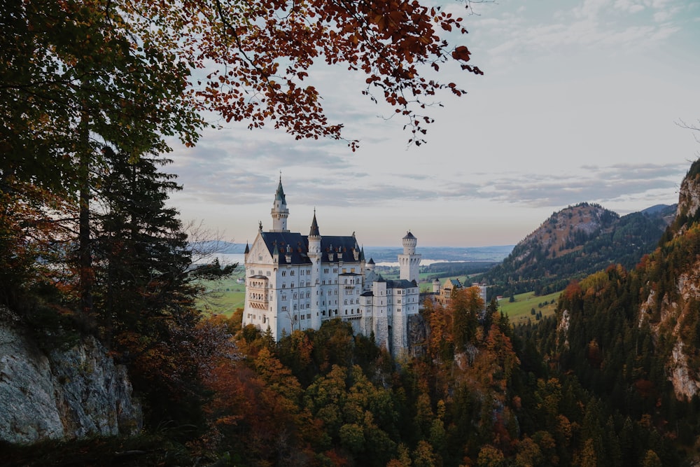 ein Schloss auf einer Anhöhe mit Schloss Neuschwanstein im Hintergrund