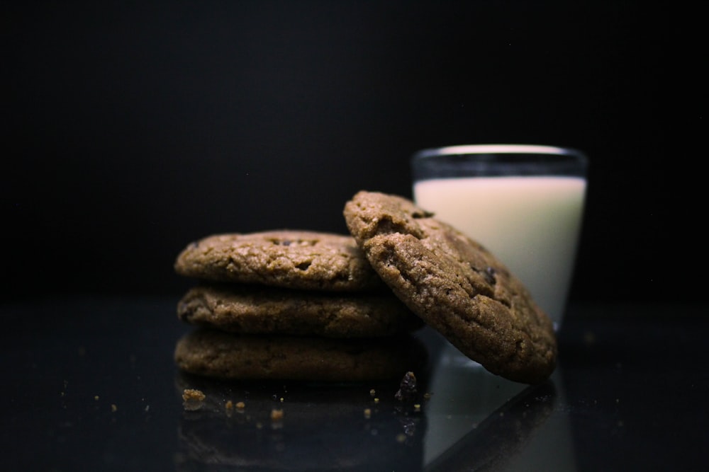 a stack of cookies next to a cup of milk