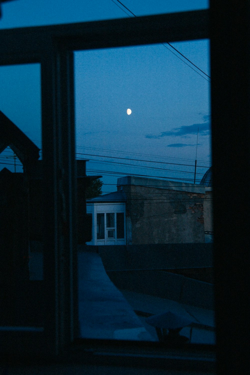 a window with a view of the moon and buildings