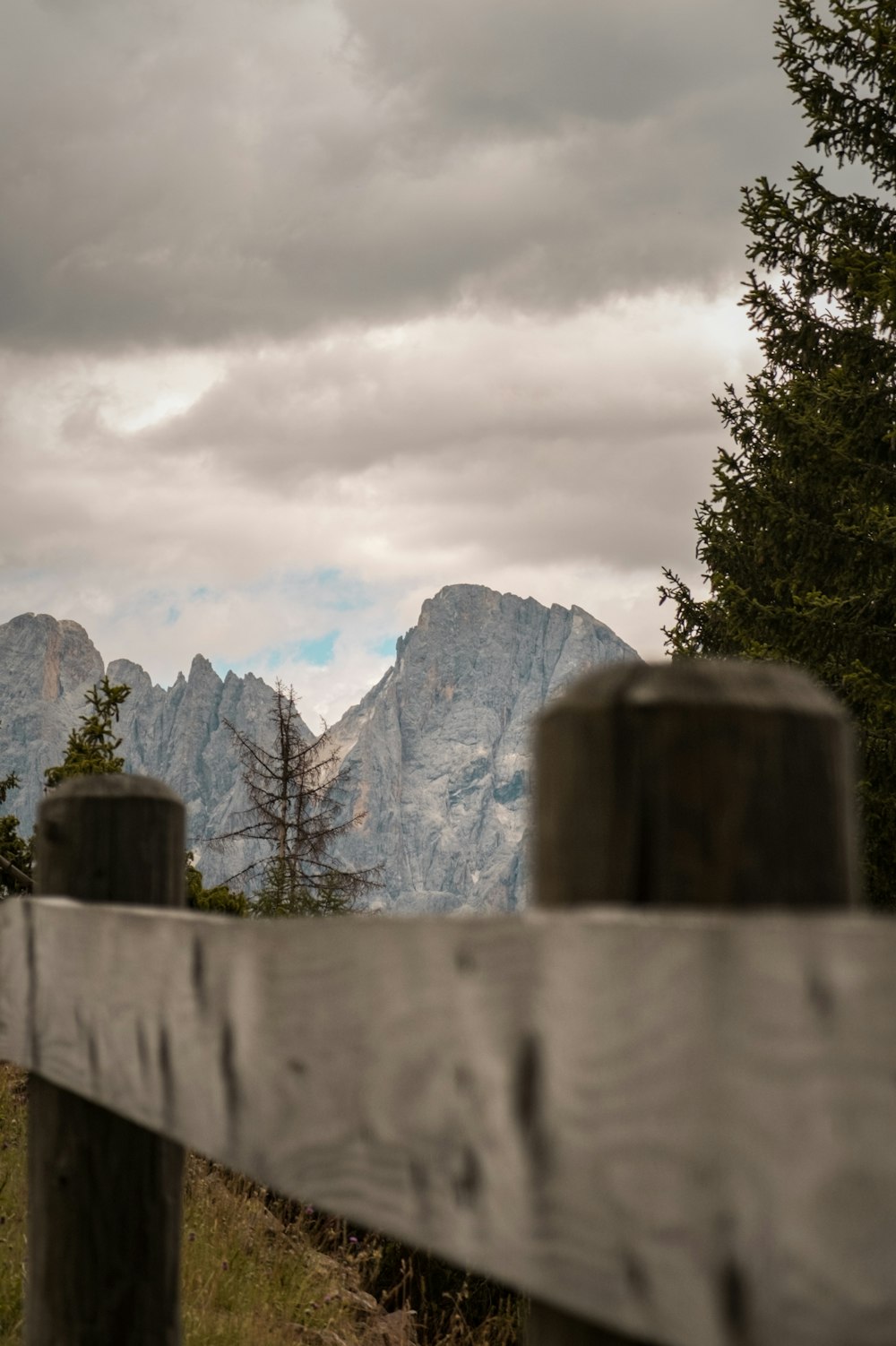 a wooden fence with a mountain in the background