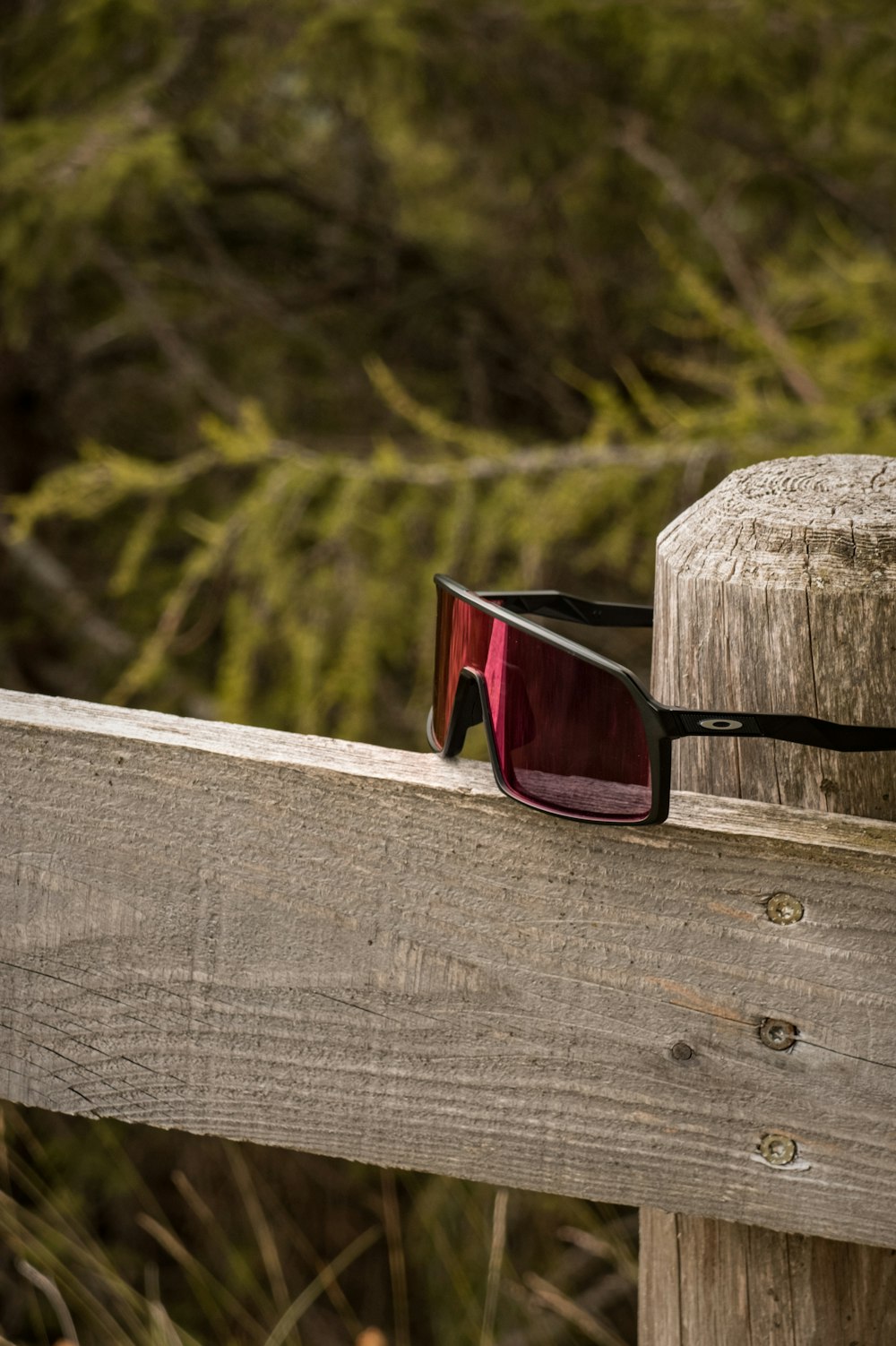 a pair of sunglasses on a wooden fence