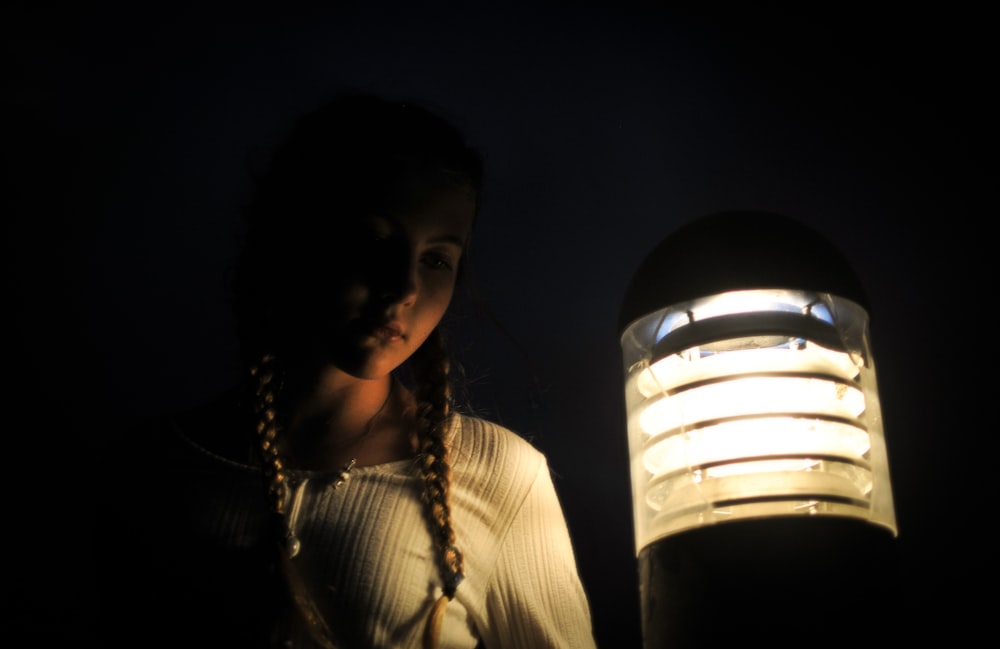 a woman standing next to a lamp