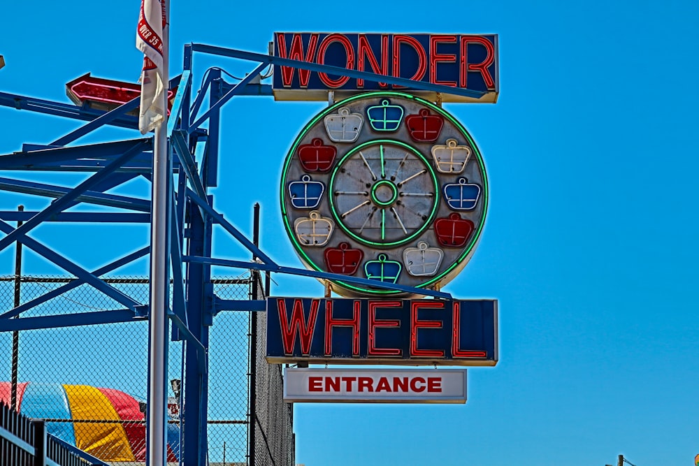 a sign with a ferris wheel in the background