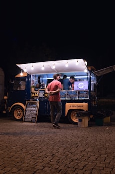 a person standing next to a food truck