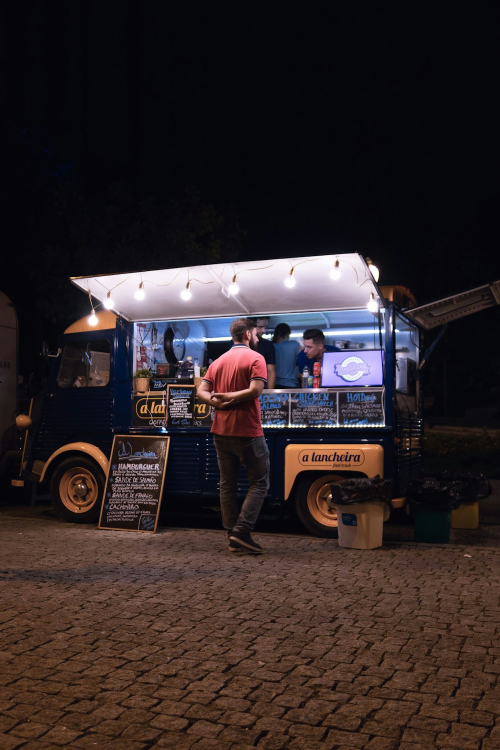 a person standing next to a food truck