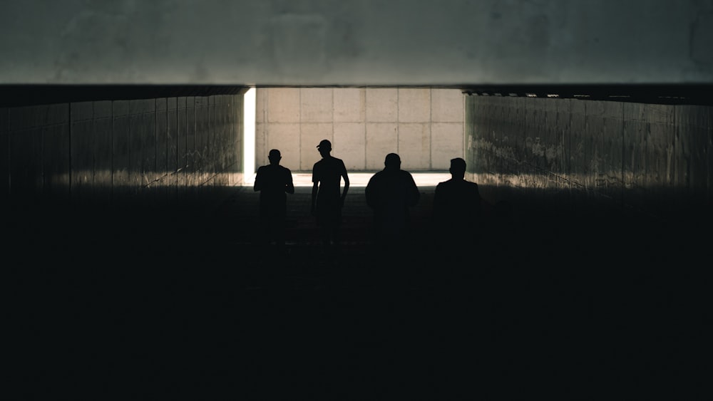 a group of people standing in front of a large stone wall