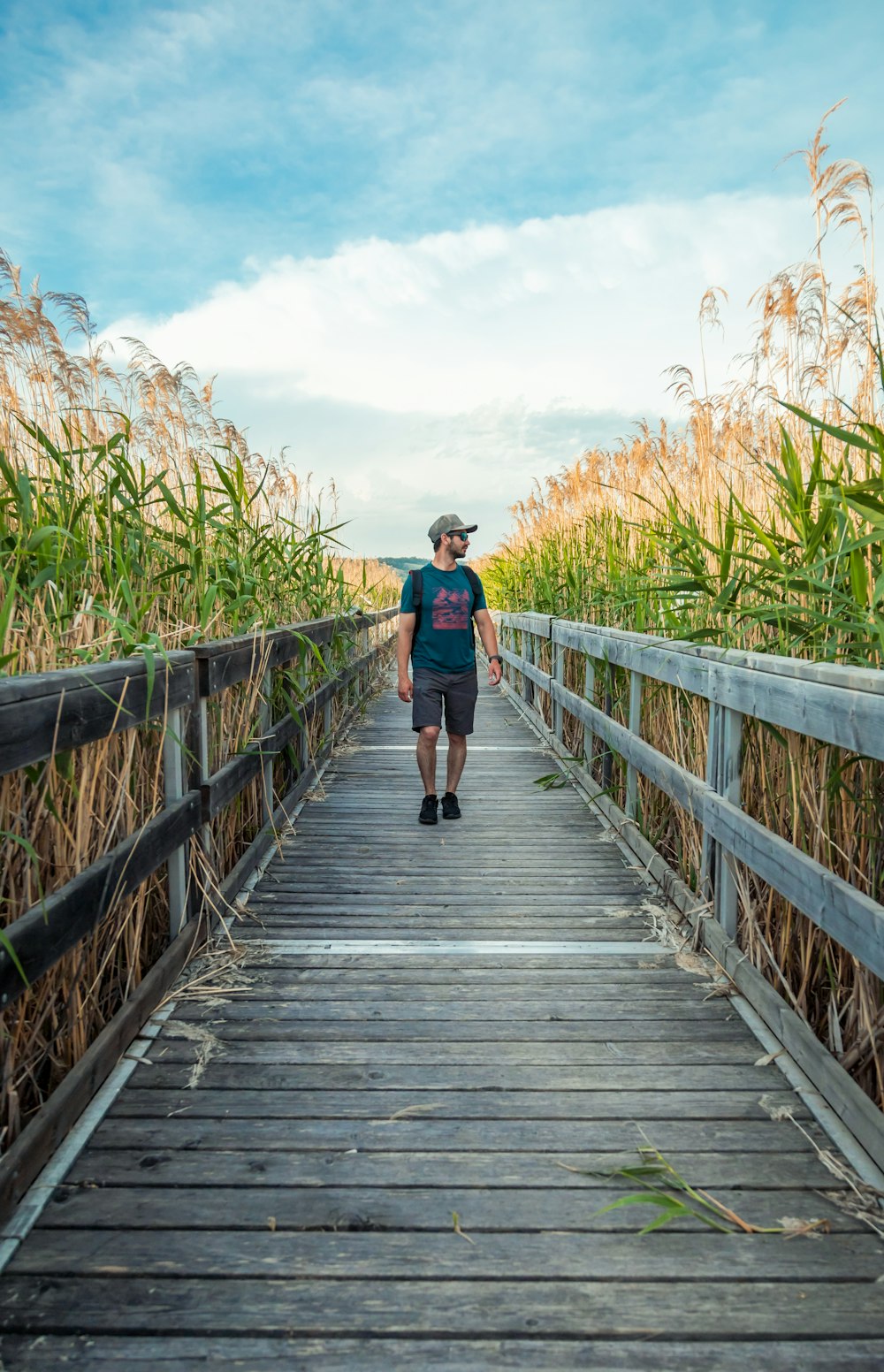 a man walking on a wooden bridge