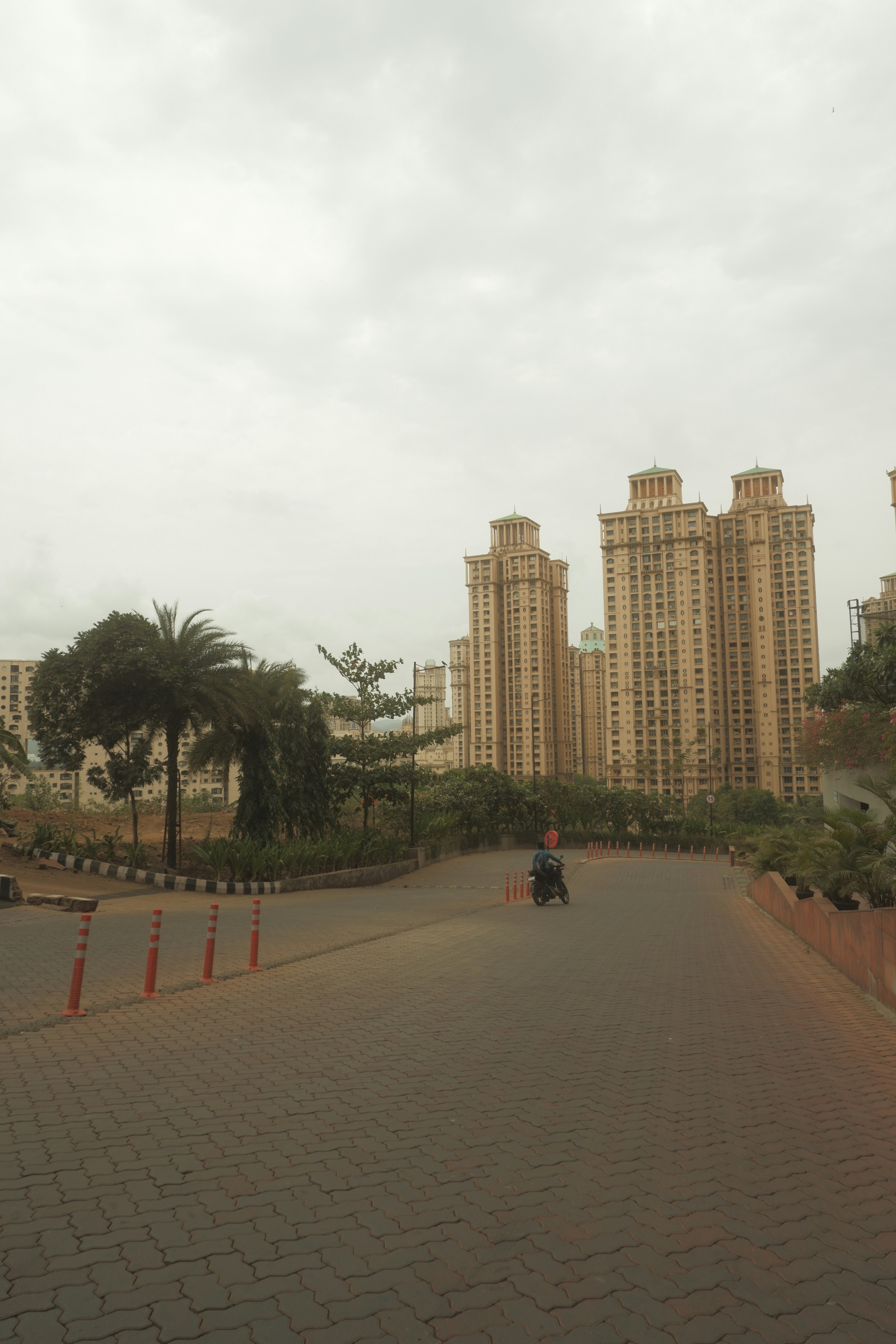 a person riding a scooter on a brick path in front of a large building