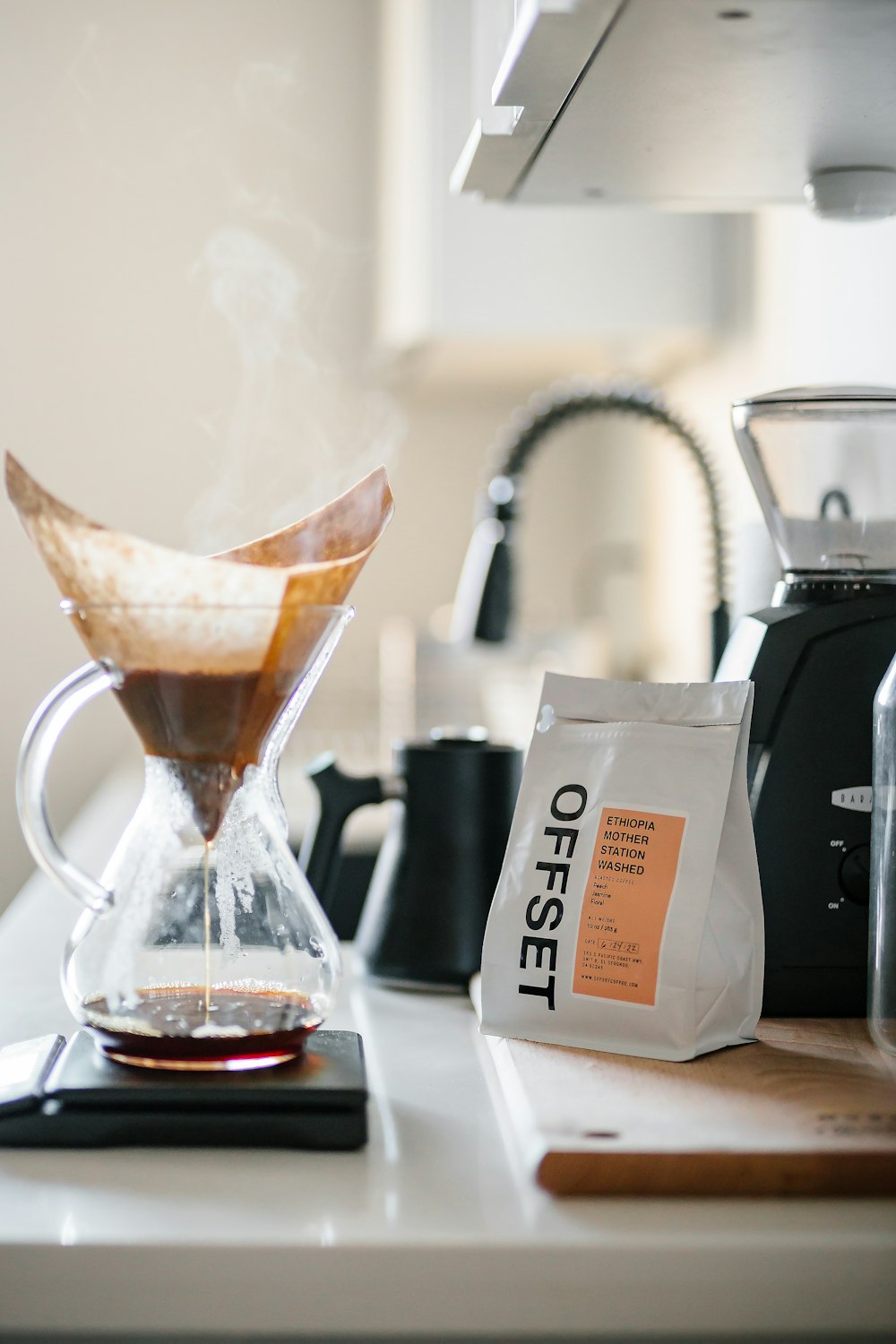 a glass of coffee and a bag of coffee on a counter