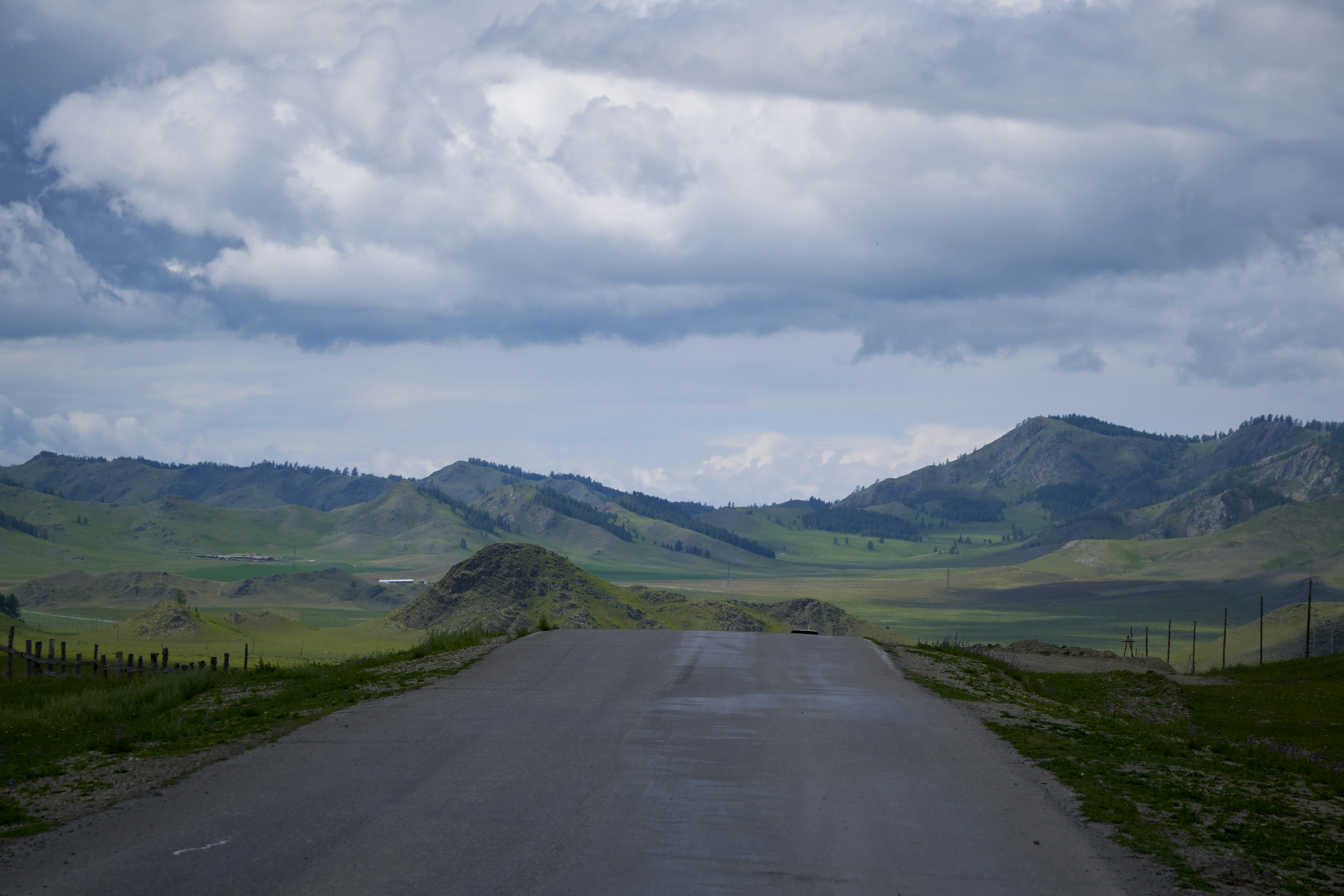 a road with grass and hills on either side of it