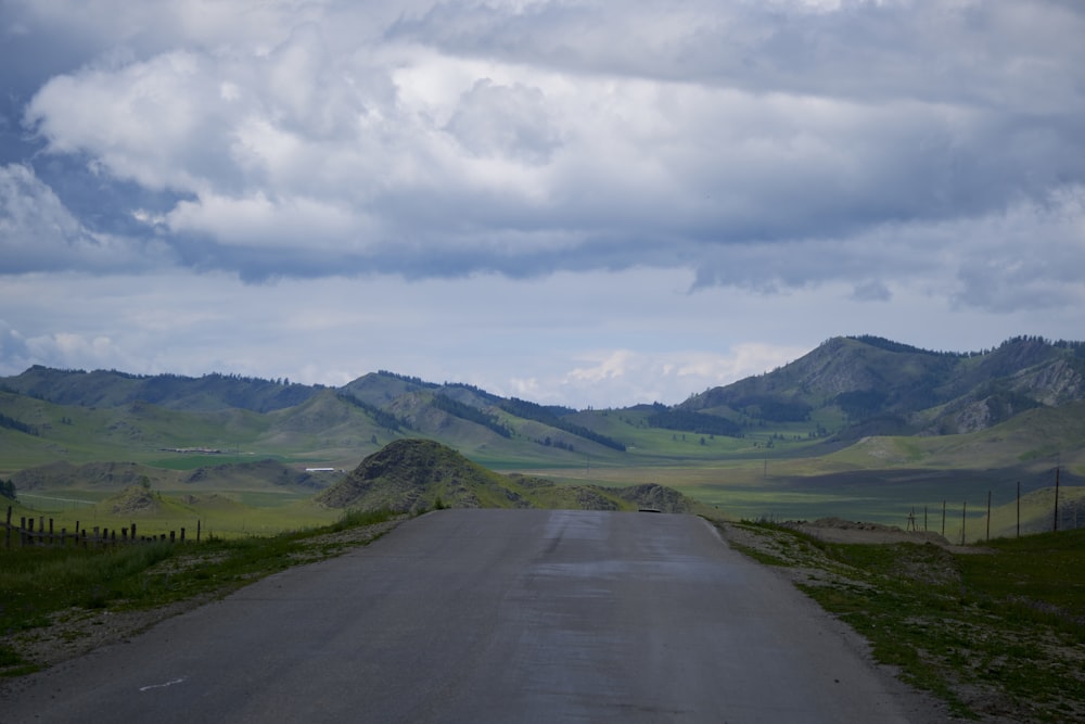 a road with grass and hills on either side of it