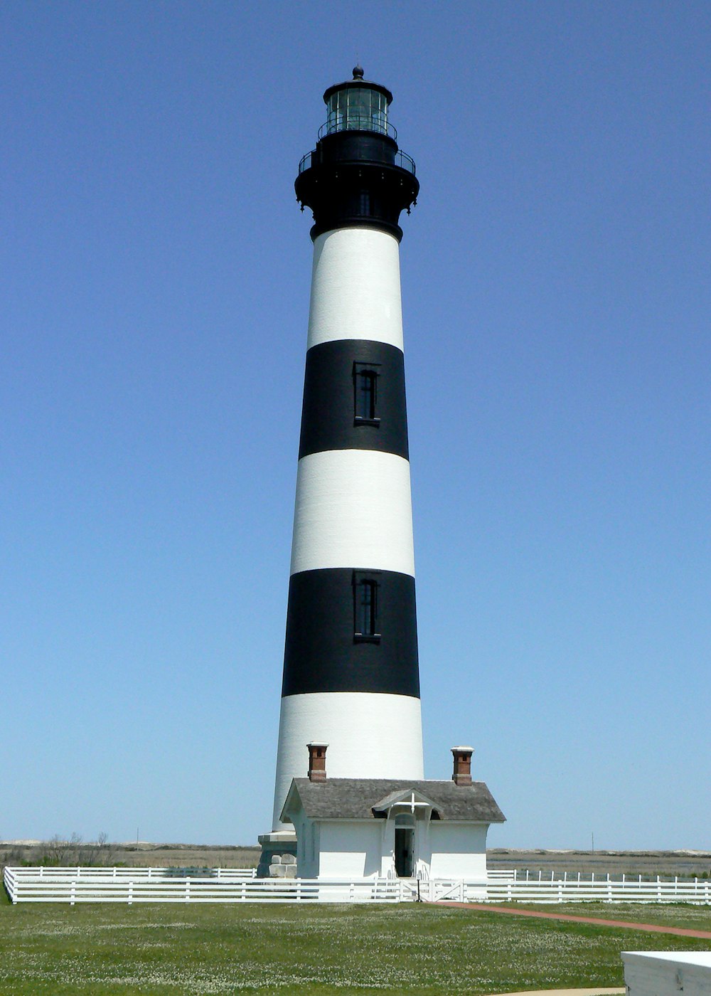 a lighthouse on a grassy hill