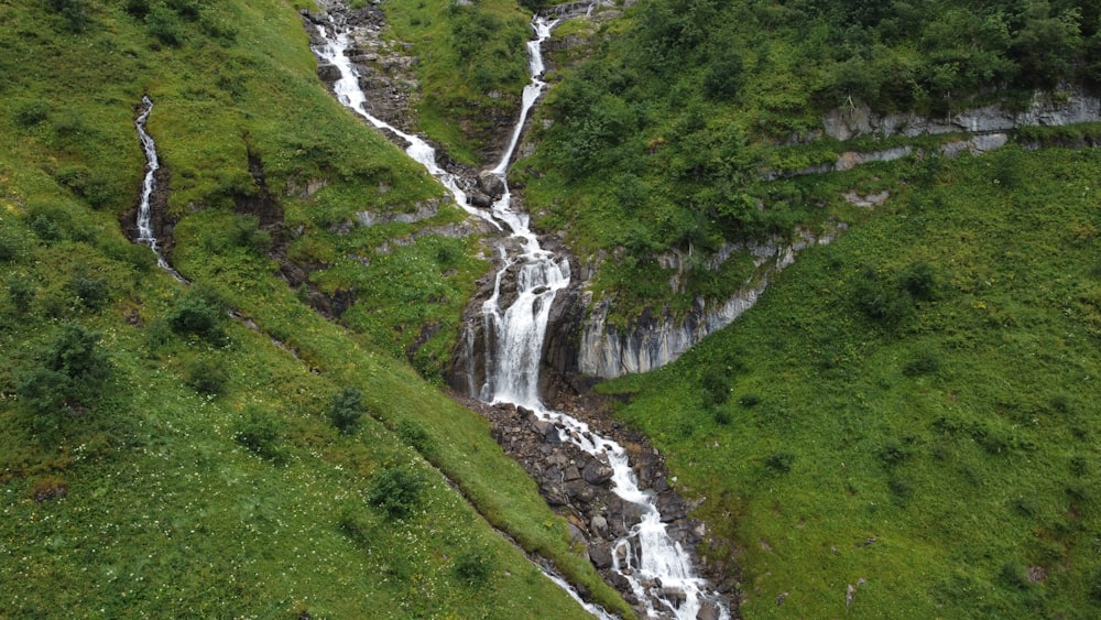 a waterfall in a green landscape