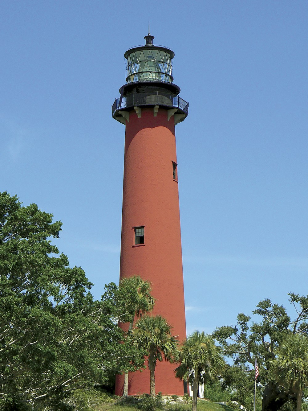 a red and white lighthouse with Currituck Beach Light in the background