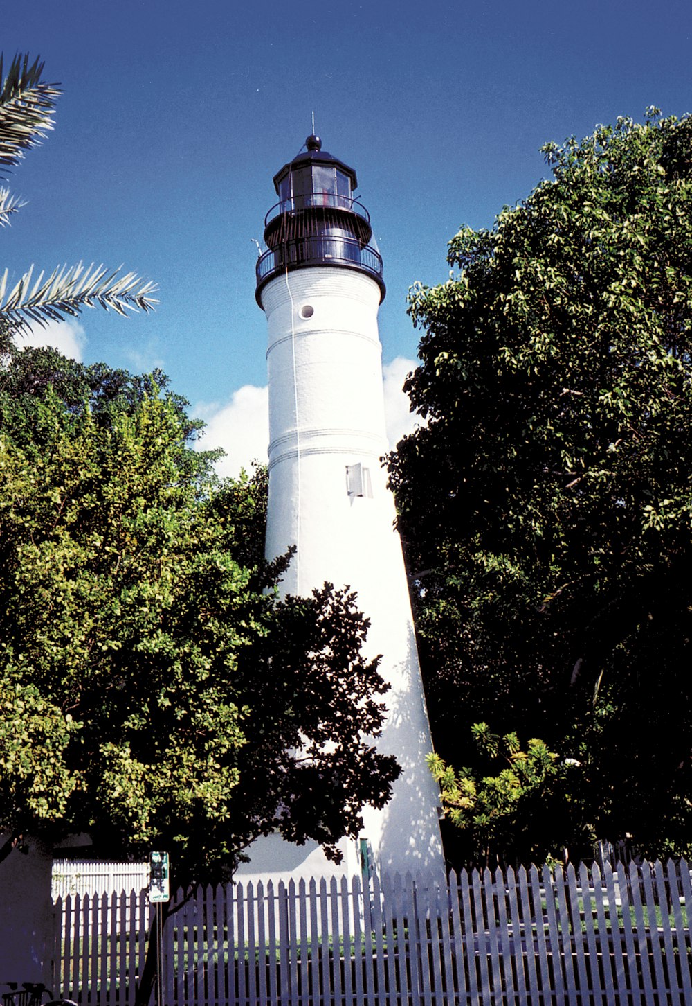 a white tower with a white top with Key West lighthouse in the background