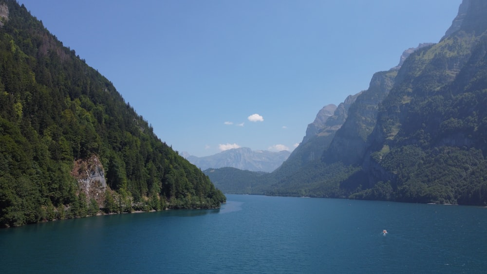 a body of water with trees and mountains around it