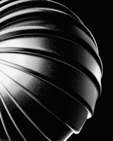 Close-up of a helix sculpture’s intricate twists, captured with elegant lighting on a clean white background.