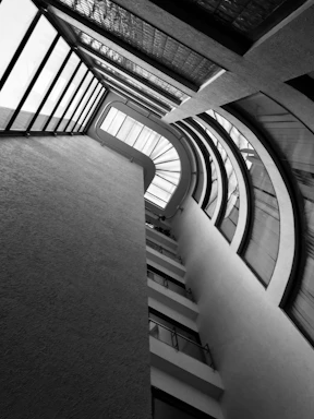 Architect at work sketching modern building plans with natural light streaming through large windows.