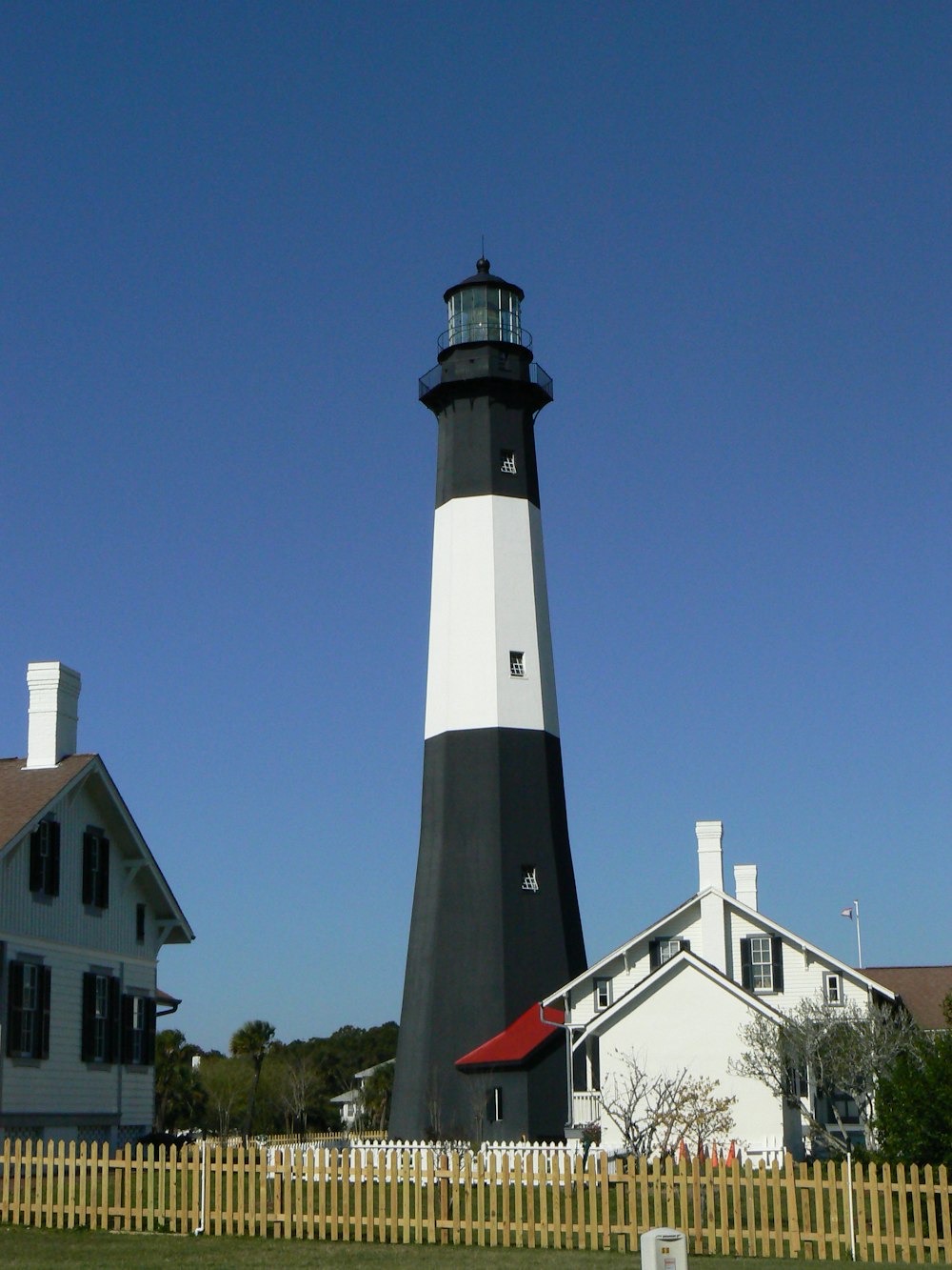 a lighthouse with a white fence