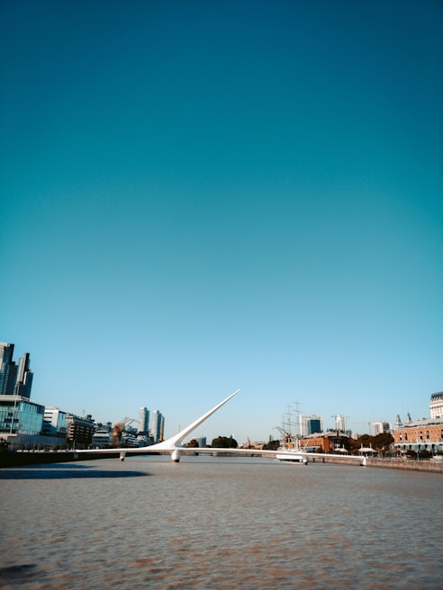 A completed modern bridge spanning over a river with clear blue skies.