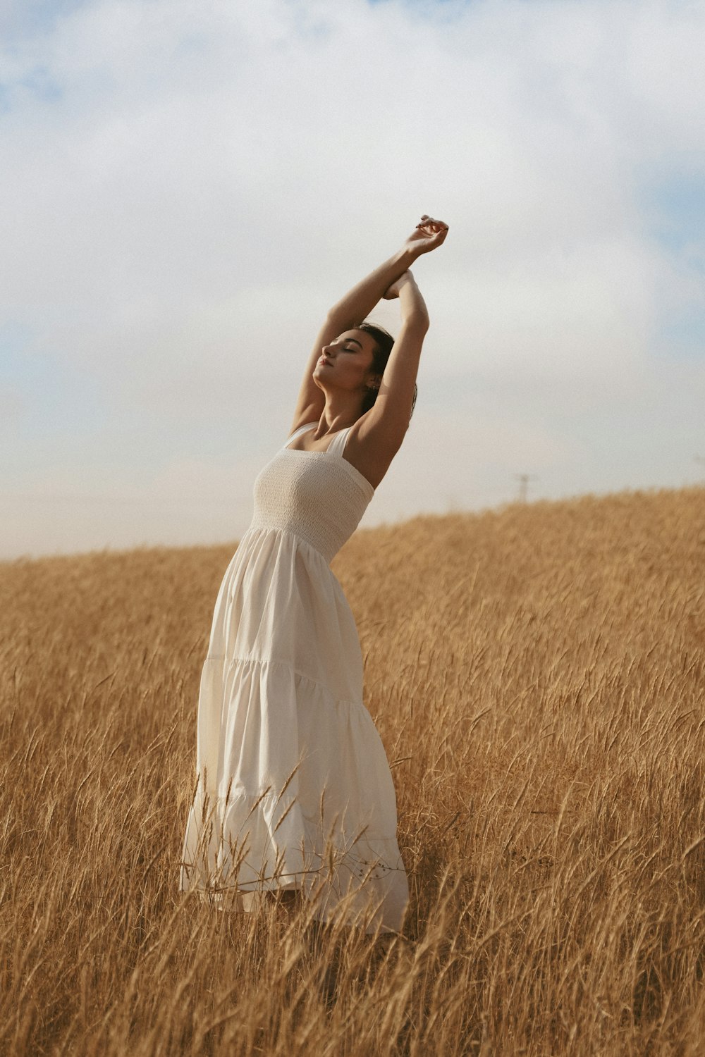 eine Person in einem weißen Kleid, die auf einem Feld steht