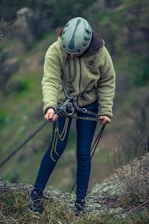 a person wearing a helmet and holding a rope