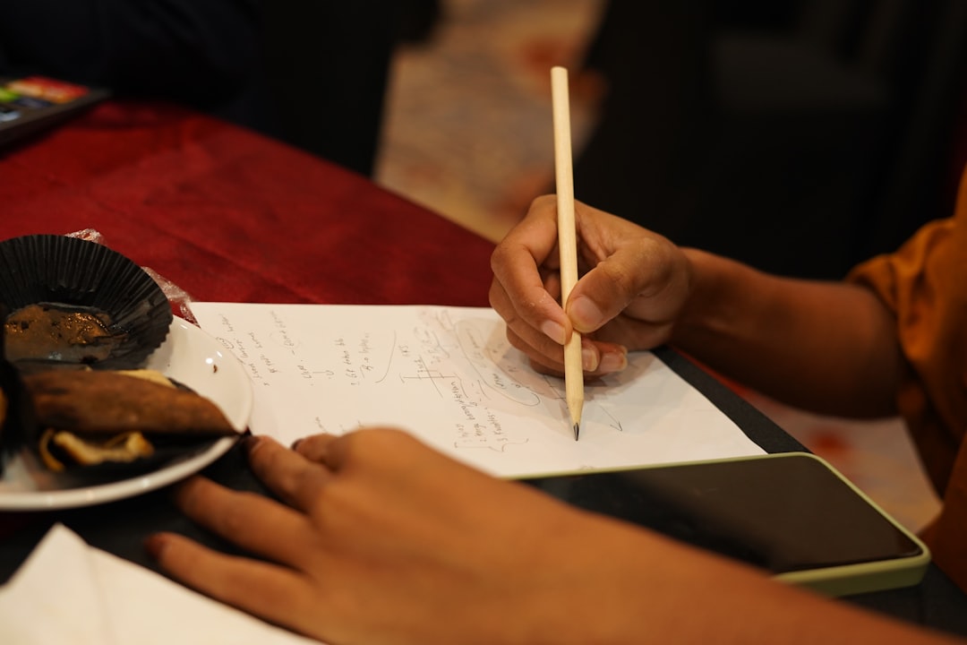 a person writing on a piece of paper,