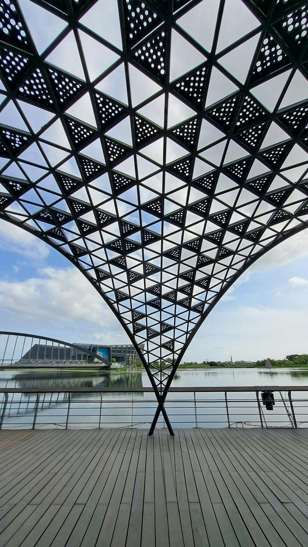 a large metal structure with a body of water in the front