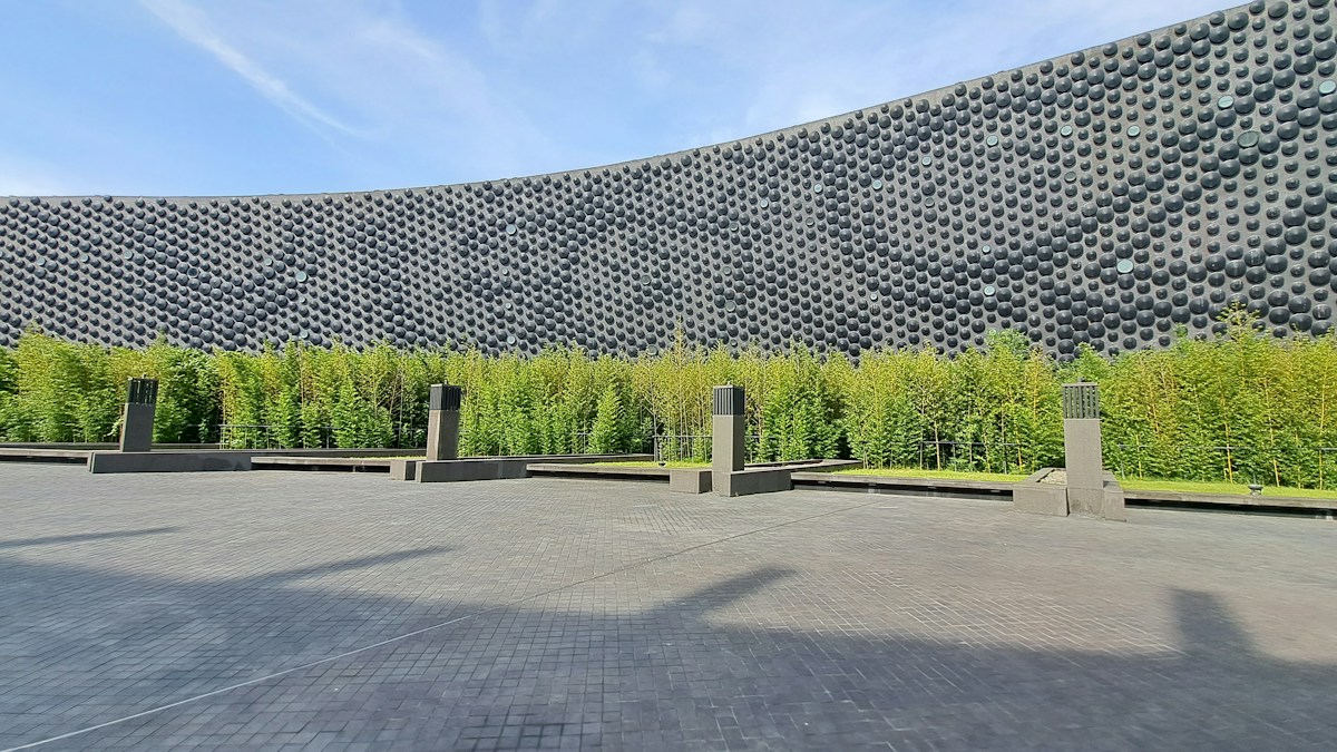 The dark dotted facade and bamboo plaza of the National Palace Museum Southern Branch in Taibao, Chiayi
