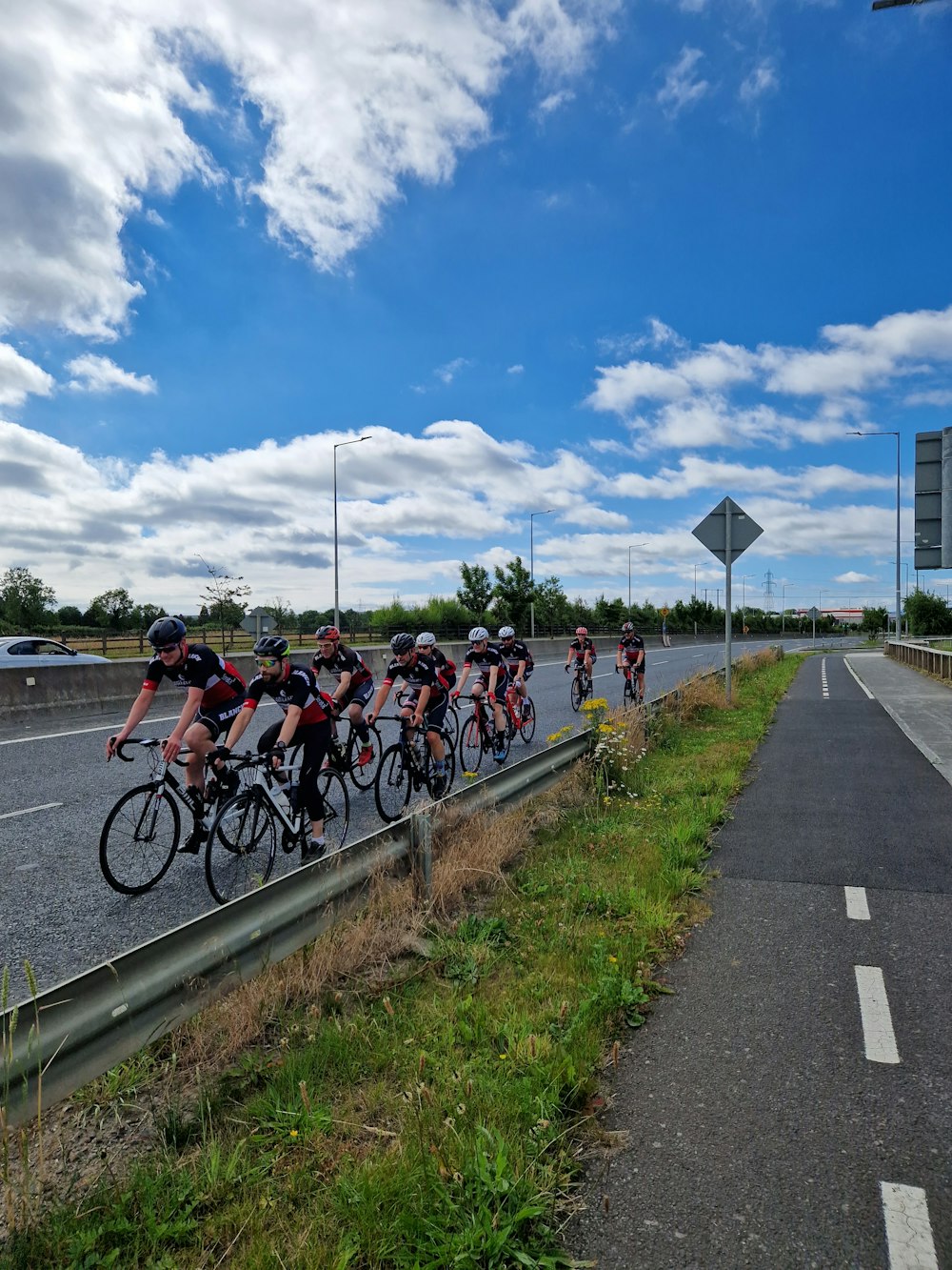 a group of people riding bikes on a road