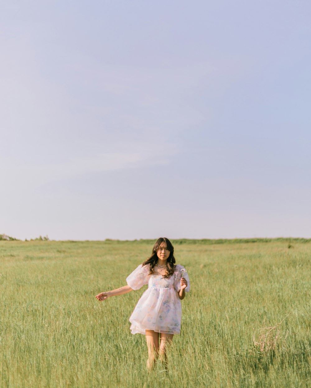 a person in a dress walking through a field