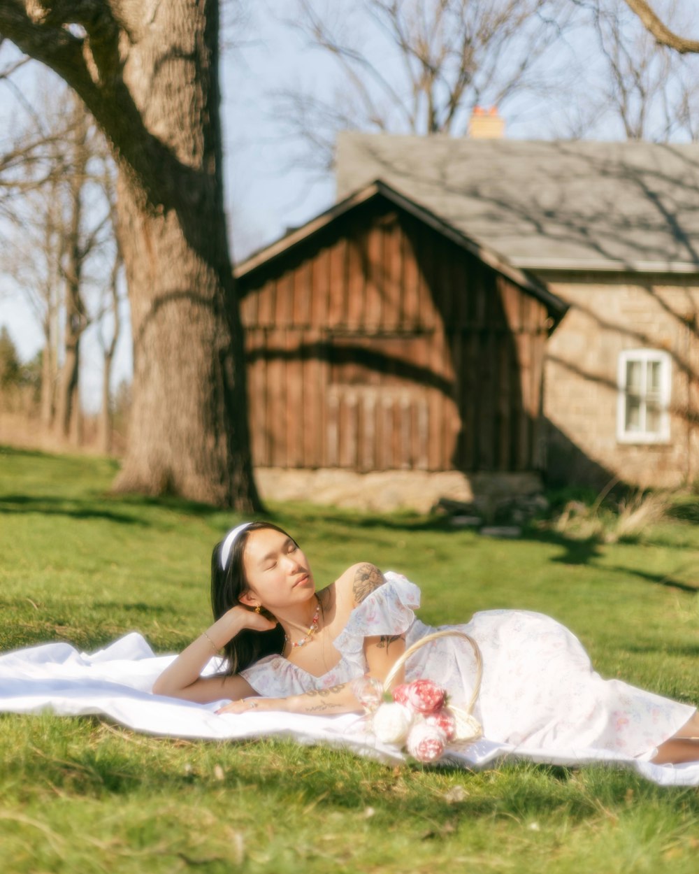 a person in a wedding dress lying on a blanket in a grassy area