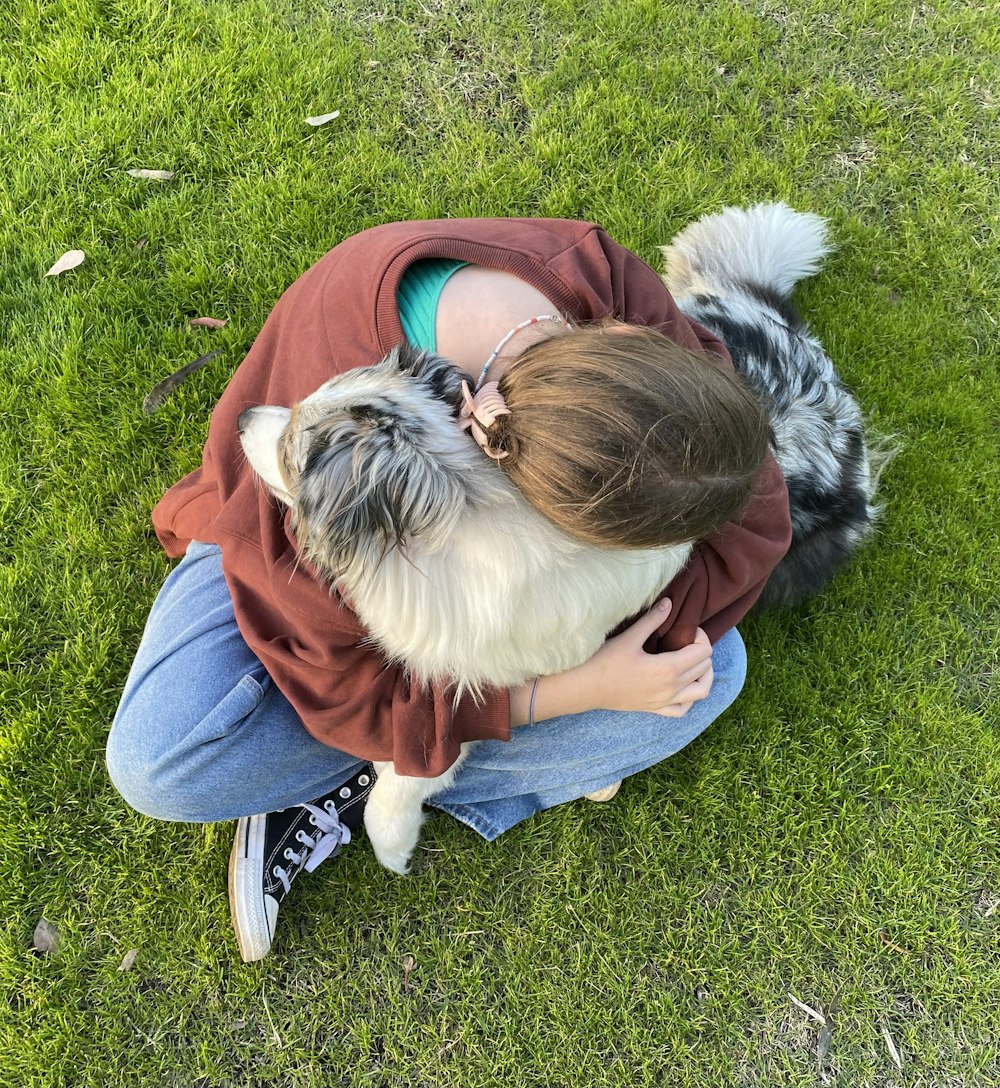 a person lying on the grass with a dog