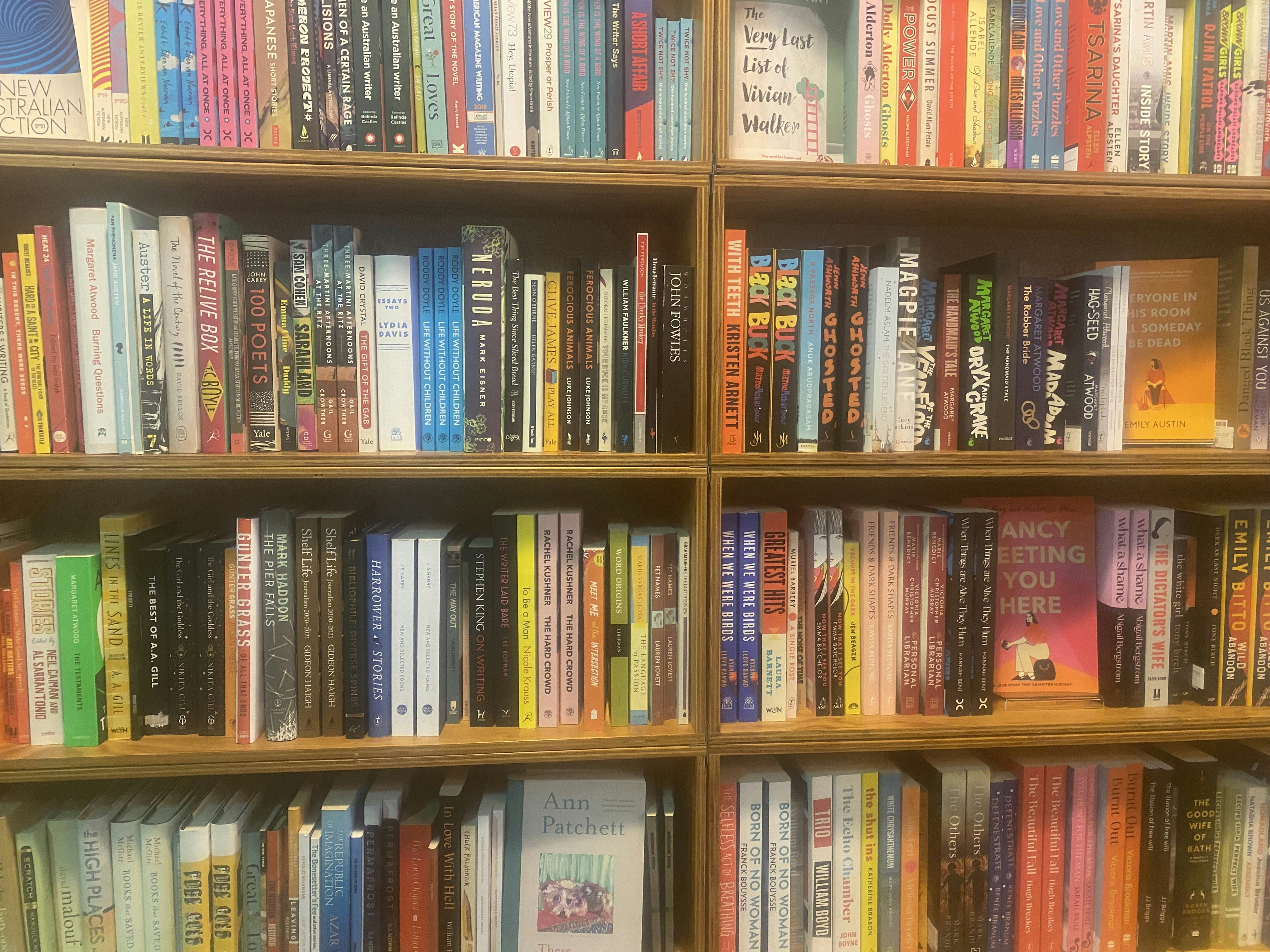 Close-up of library book spines arranged neatly on wooden shelves