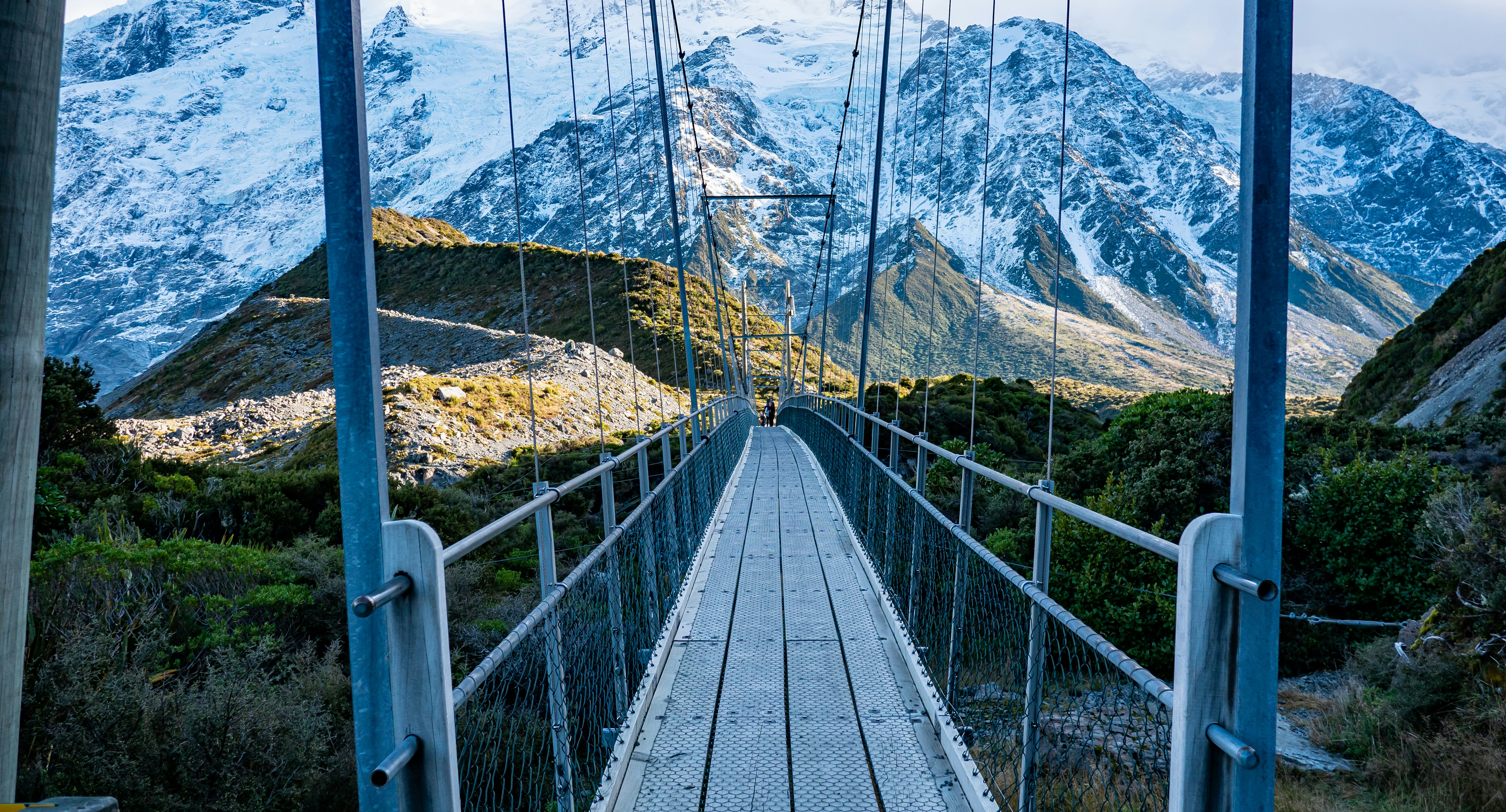A bridge with cables going over a mountain range photo – Free Mount ...