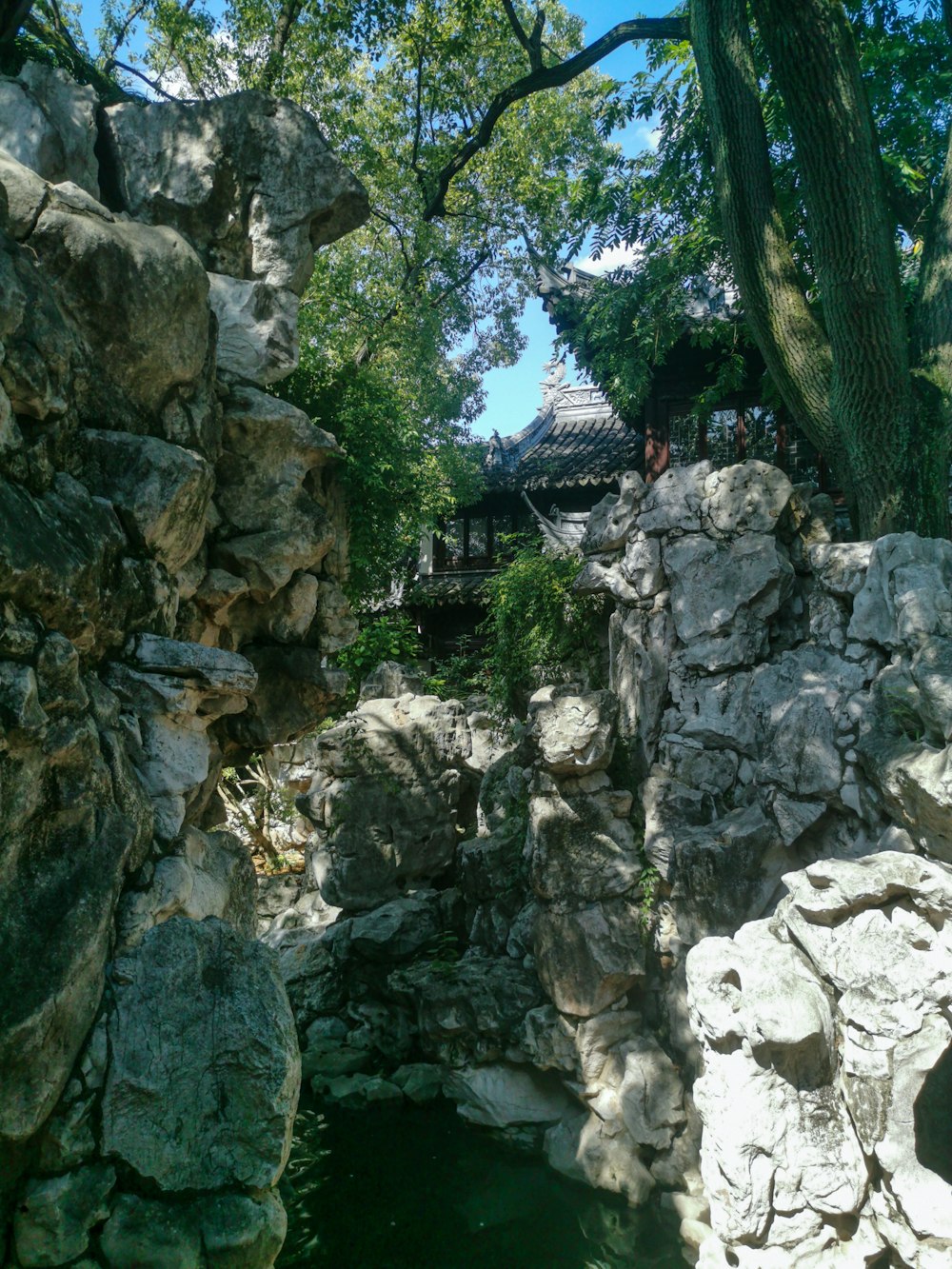 a stone wall with a building in the background